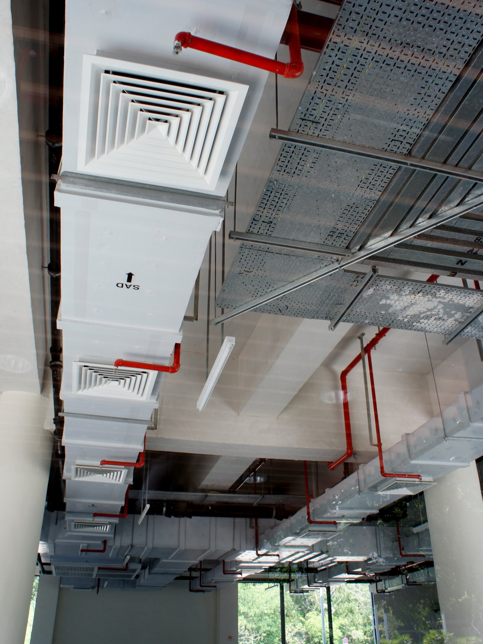 Exposed HVAC ductwork, ceiling diffusers and mechanical services above a commercial ceiling